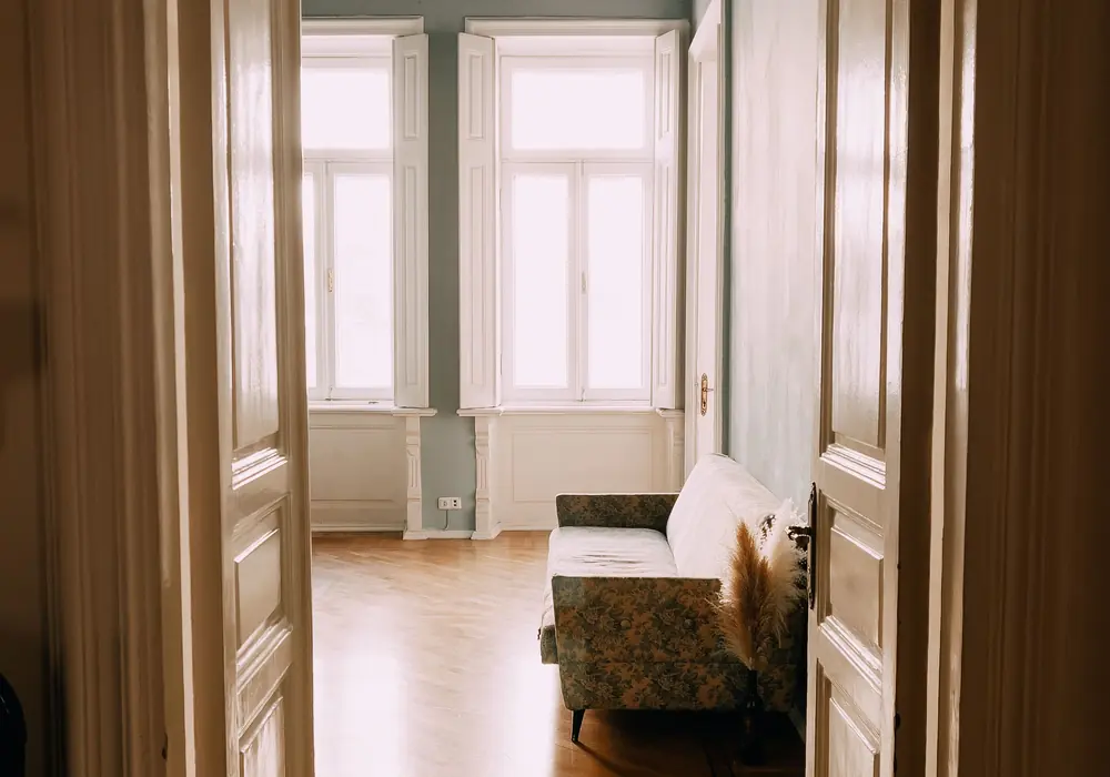 Gang einer Altbauwohnung mit Kassettendecke und offener Flügeltür.