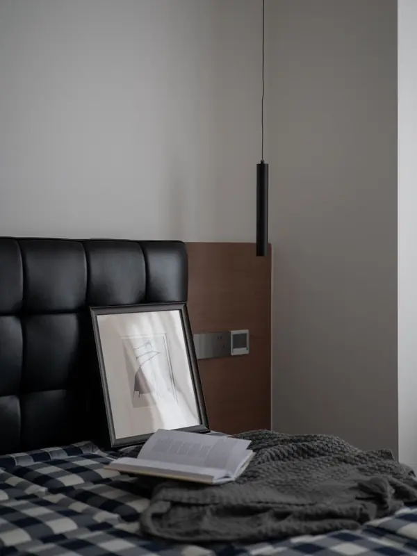 Bett mit Lederkopfteil und kariertem Überwurf