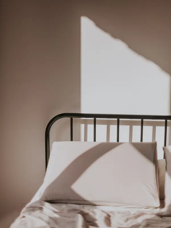 Bett mit Metallkopfteil im Morgenlicht