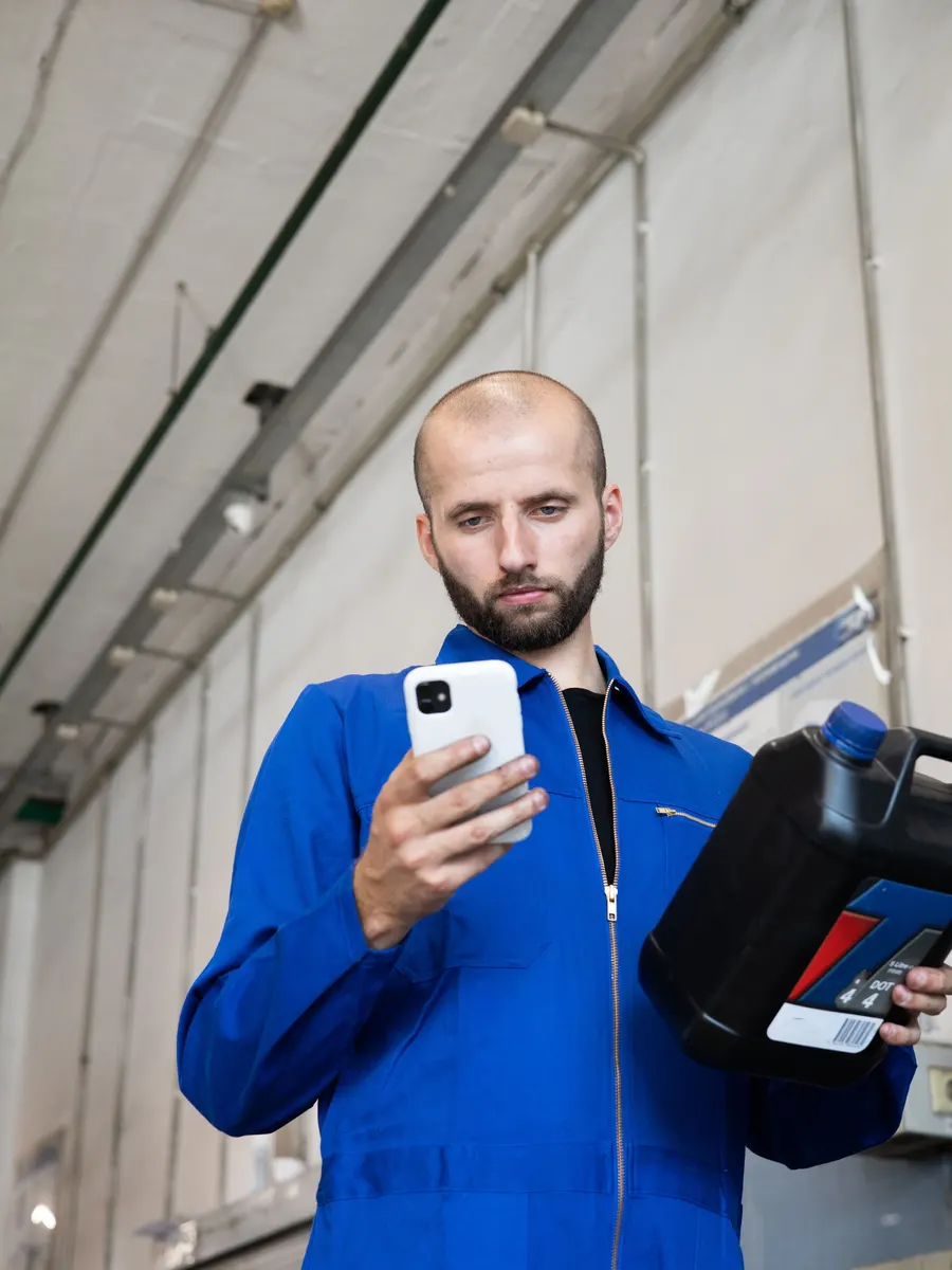 Techniker in der Werkstatt am Telefon.