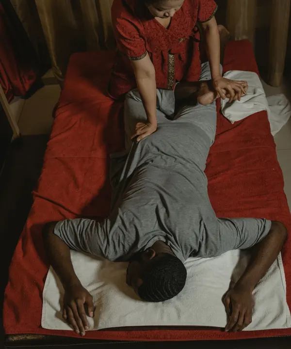 Traditionelle Thai-Massage auf der roten Bodenmatte, von oben.