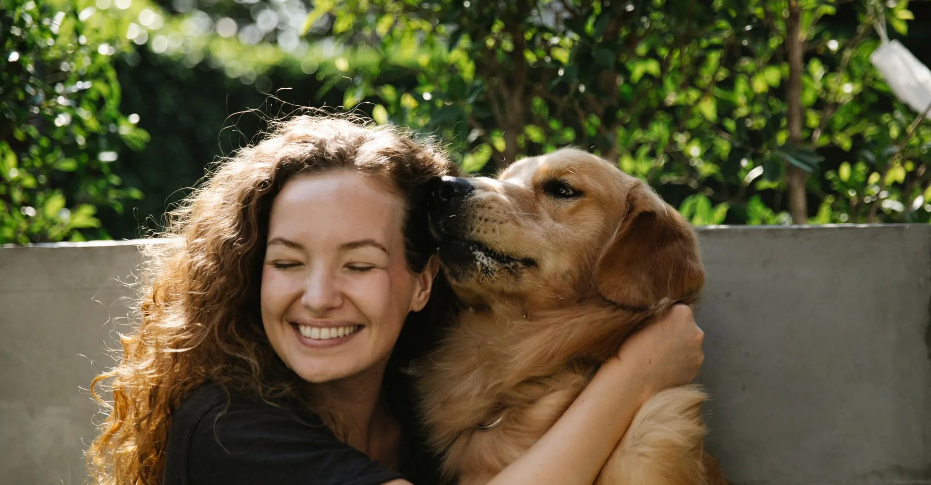 Frau umarmt ihren Hund im Park