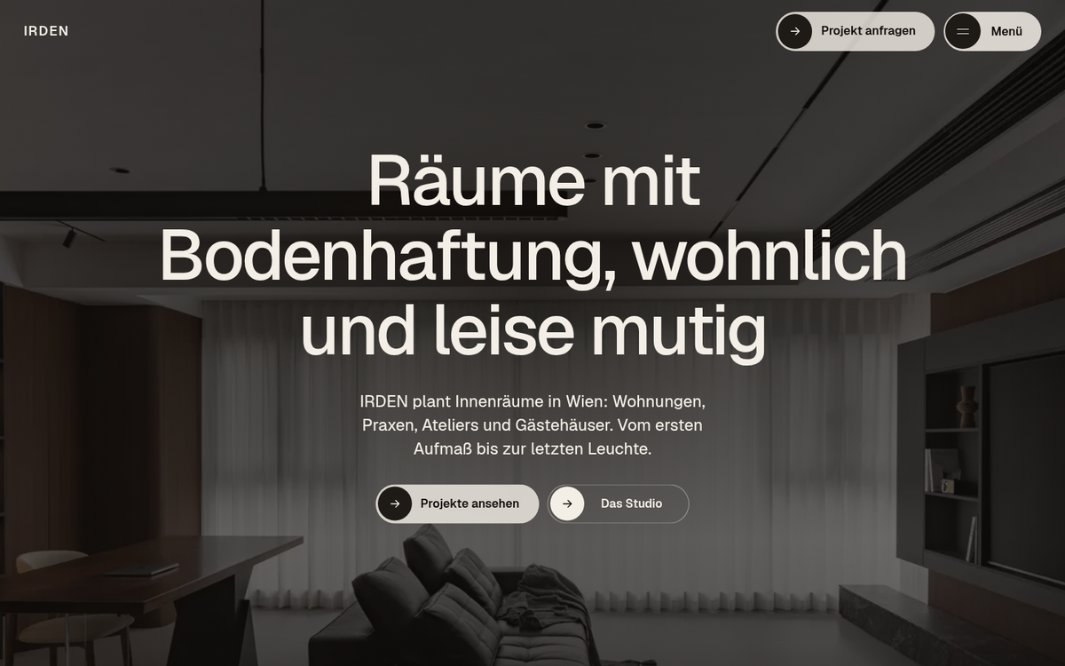 Beispiel-Design einer Website für ein Studio für Innenarchitektur: dunkler Wohnraum mit Nussholz und Ledersofa, darüber die Überschrift „Räume mit Bodenhaftung, wohnlich und leise mutig“, oben die Wortmarke „IRDEN“ und die Buttons „Projekt anfragen“ und „Menü“
